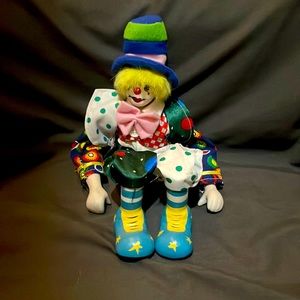Porcelain clown face with I believe ceramic hands and shoes. Vibrant colors.